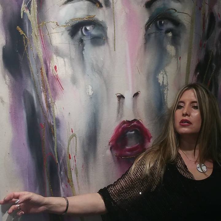 April Anselona standing in front of her artwork